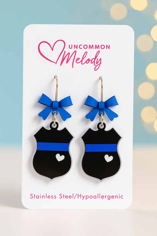 Product Title:
Blue Line Police Badge Earrings with Bow – UV Printed Acrylic | Uncommon Melody